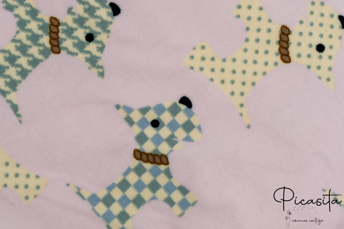 Detalle de toalla rosa con dibujos de perros tipo terrier con patrones geométricos.