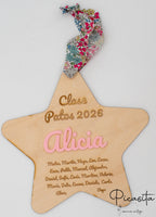 Placa de madera con forma de estrella personalizada con lista de alumnos y cinta floral de colores.