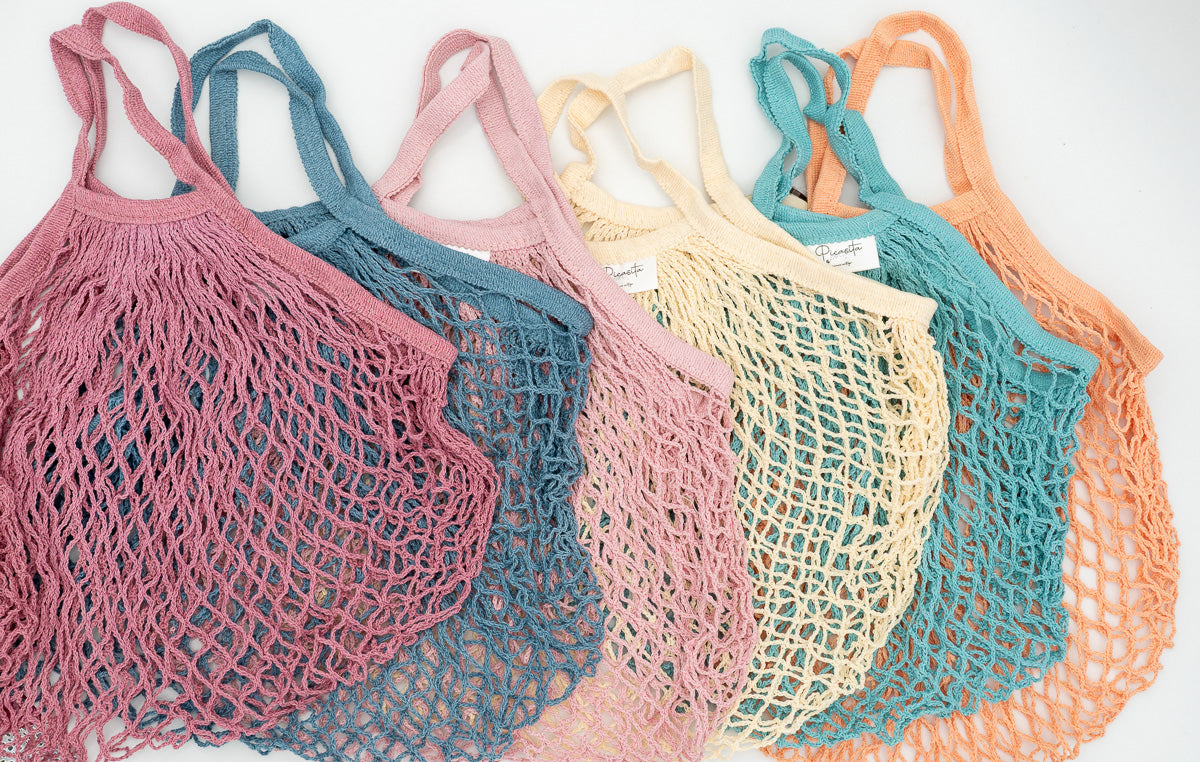 Conjunto de seis bolsas de malla de colores alineadas mostrando la variedad cromática disponible.