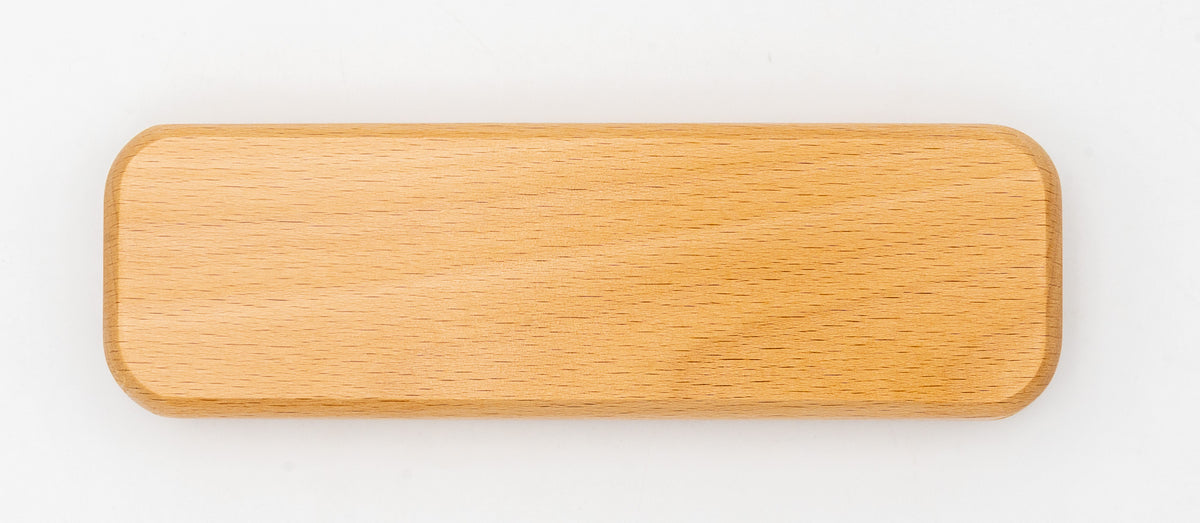 Estuche de madera de haya cerrado, de forma alargada y con esquinas redondeadas.