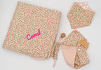 Pink set with a floral blanket embroidered with the name Coral, bandana bib, pink muslin square with a wooden teether and dummy clip.