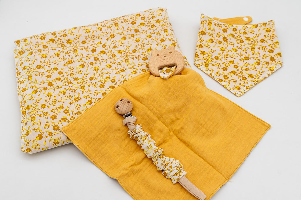 Mustard set with a floral blanket, bandana bib, mustard muslin square with a wooden bear teether and a dummy clip with a wooden clasp.