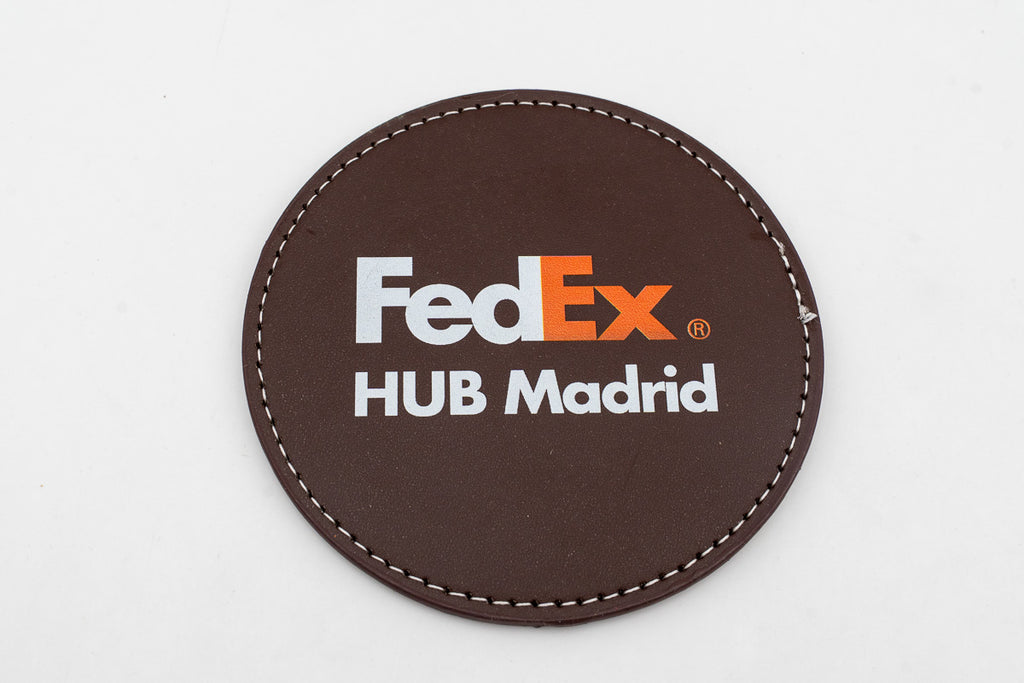 Round brown coaster with a colour FedEx logo.