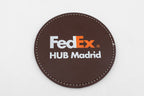 Round brown coaster with a colour FedEx logo.