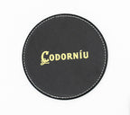 Round black coaster with a gold-coloured Codorníu logo.