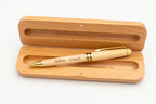 Open case with a light wooden capped pen and gold-coloured details.