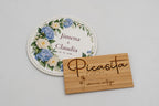 Round white coaster with blue flowers, Jimena and Claudia.