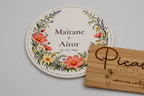 Round white coaster with colourful flowers, Maitane and Aitor.