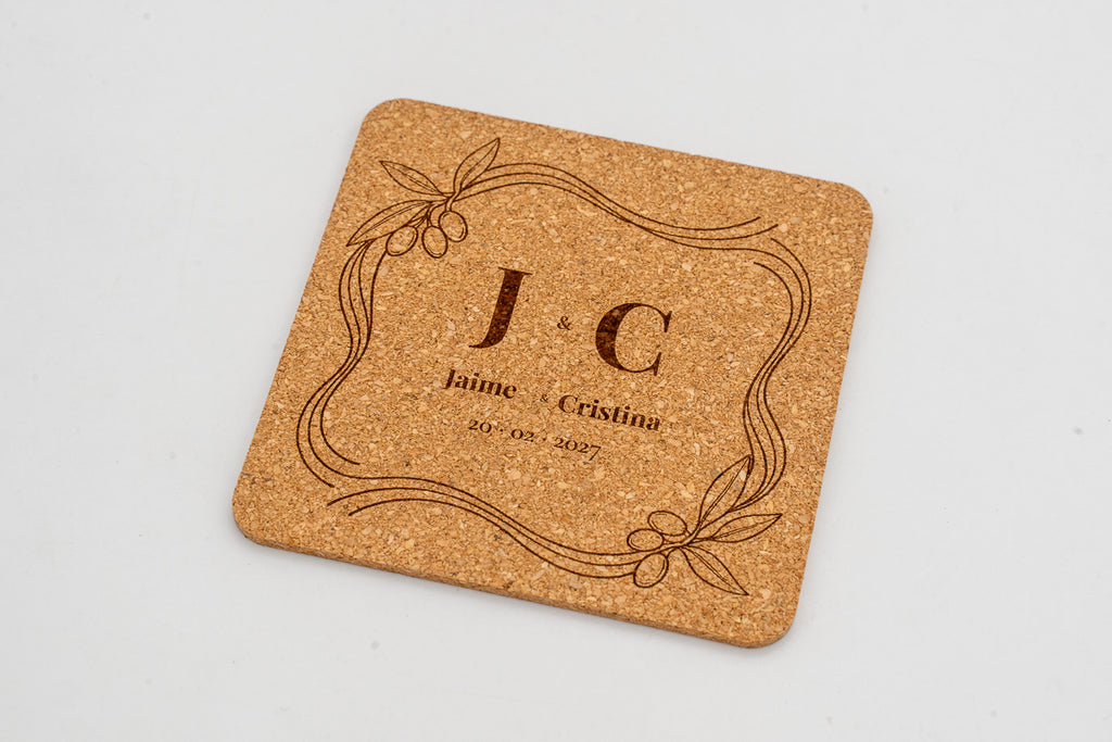Square cork coaster with a decorative frame and initials J and C.