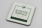 Square white coaster with a green Authentic Heritage logo.