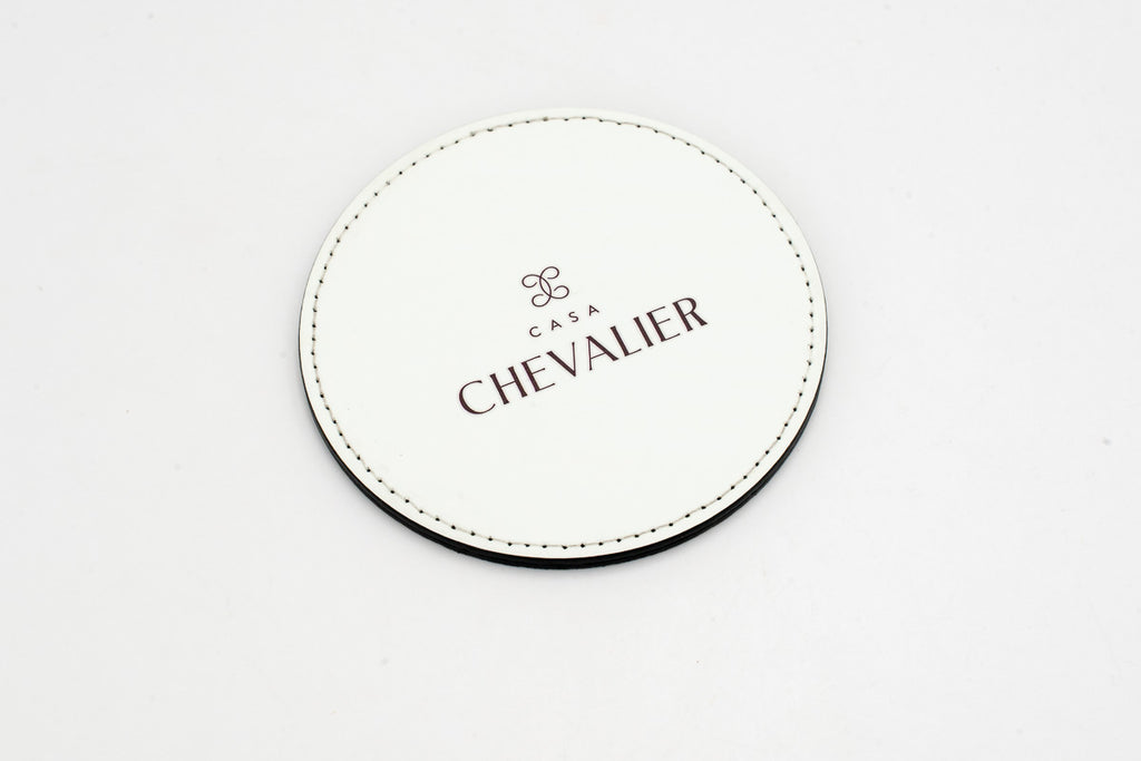 Round white coaster with a grey Chevalier logo.