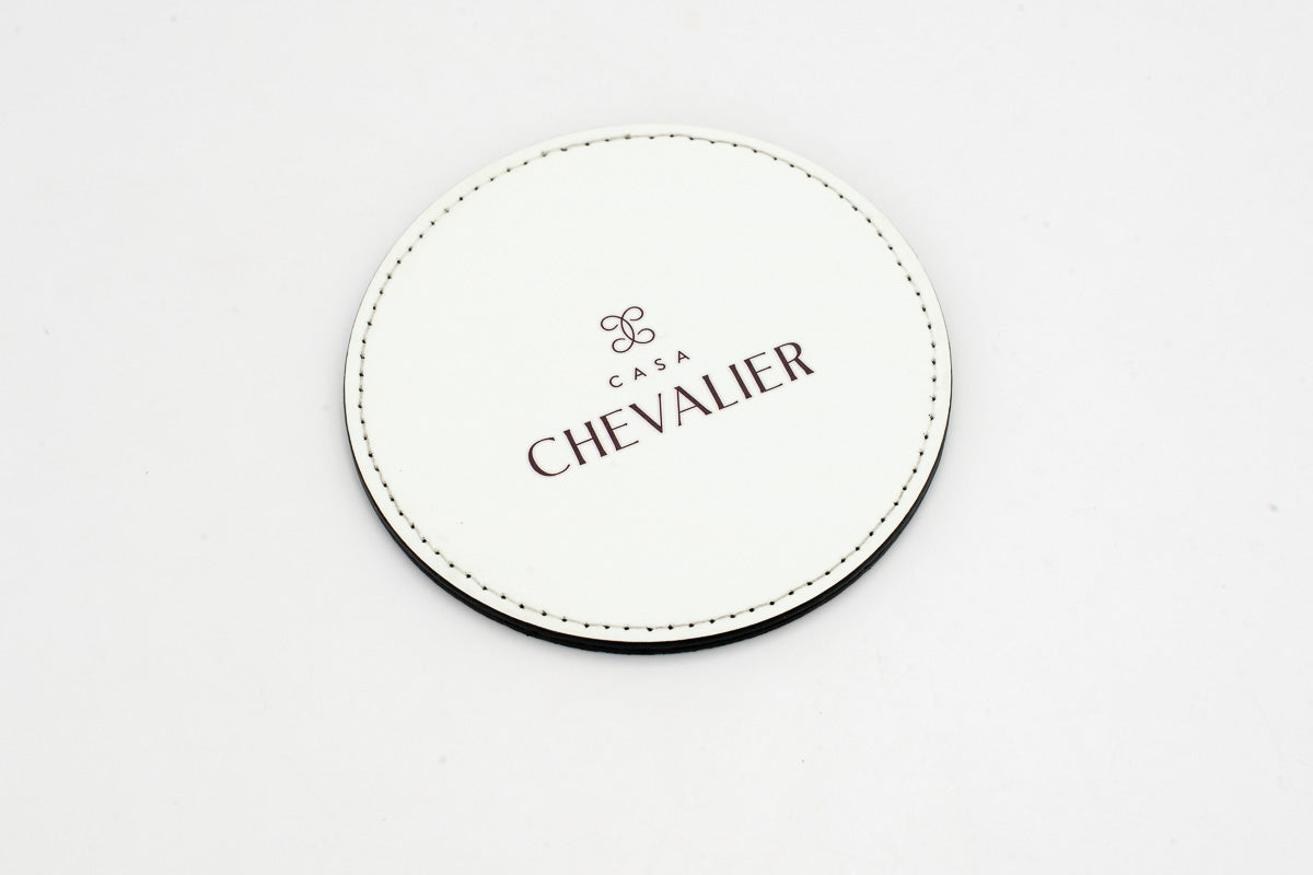 Round white coaster with a grey Chevalier logo.