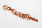 Gathered fabric dummy clip with flowers on a terracotta background and a wooden clip