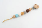 Dummy clip with earth-tone, white and blue crochet-covered beads and a wooden clip