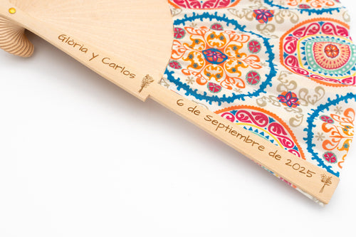 Fan with colourful mandala fabric and the names Gloria and Carlos with the date engraved in the wood