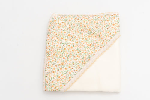 Mustard baby swaddle blanket, folded, with a floral print hood and matching lace trim.