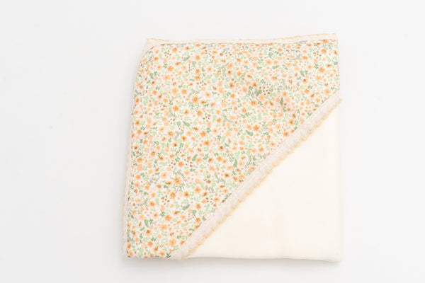 Mustard baby swaddle blanket, folded, with a floral print hood and matching lace trim.