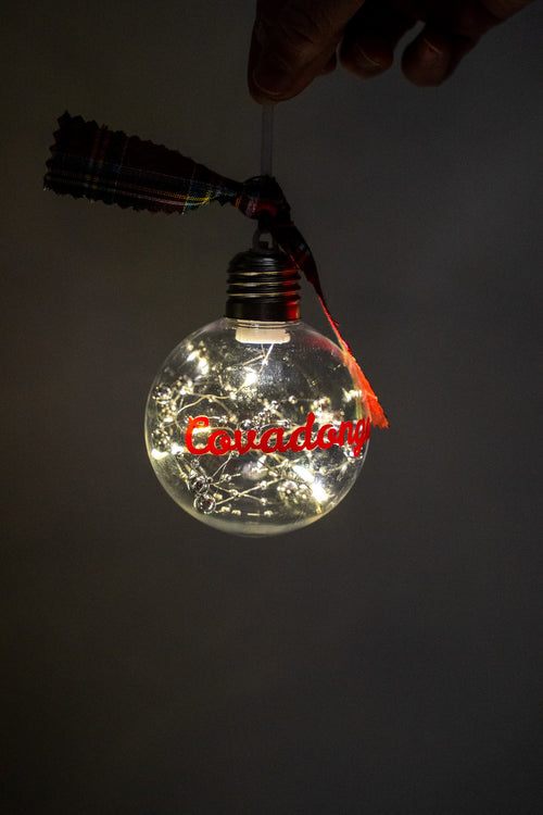 Lit LED ornament with the red name Covadonga and silver beads.