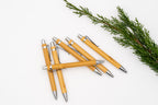 Bamboo pens with shiny silver-coloured clips, push buttons and tips.