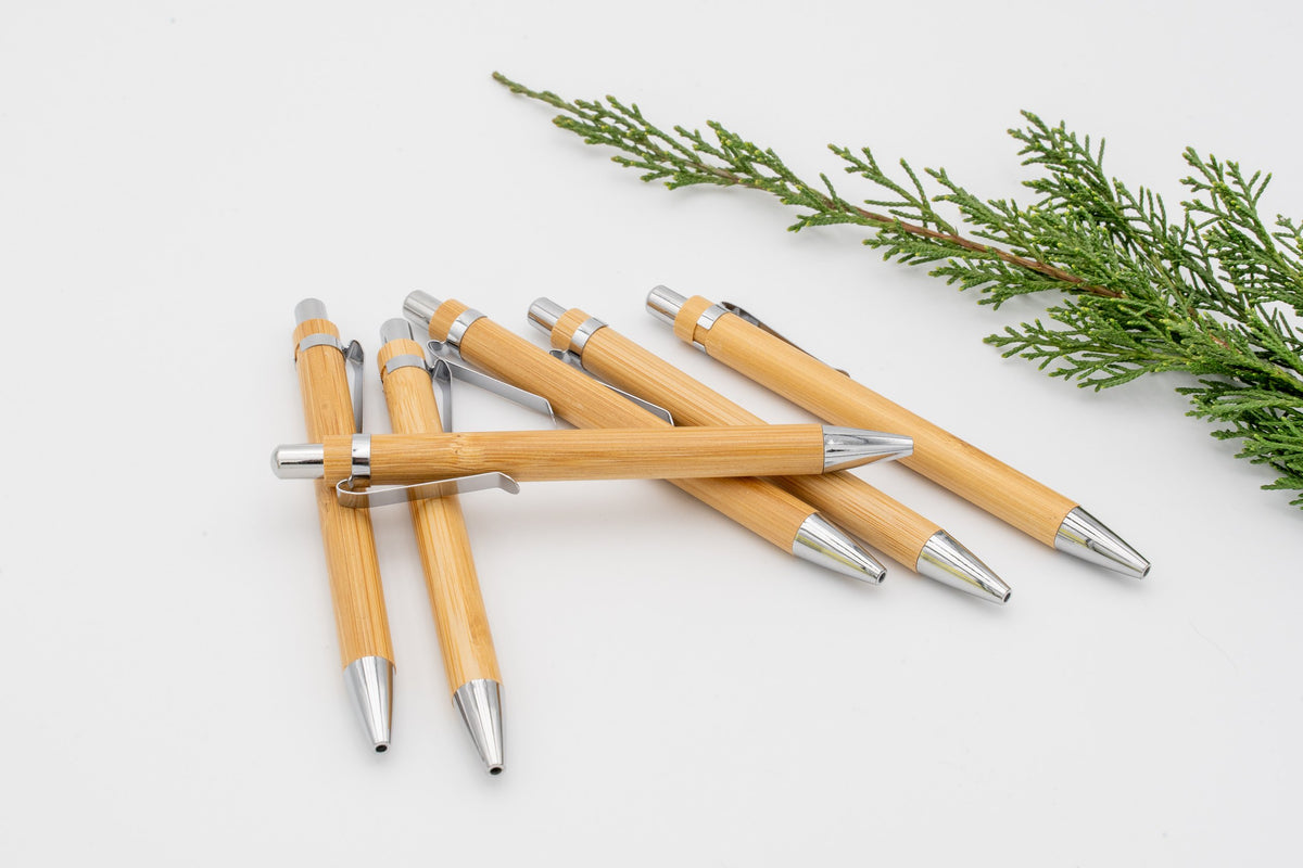 Group of bamboo pens with silver-coloured rings and metal parts.