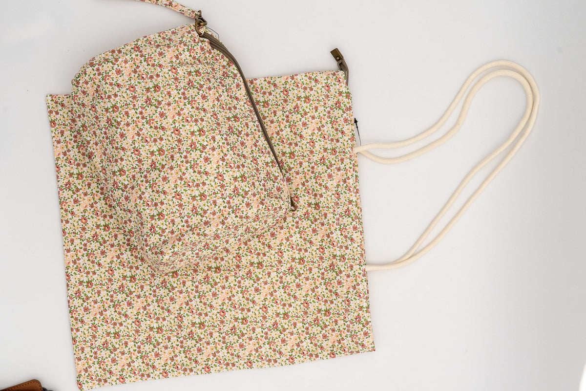 Toiletry bag on a fabric bag with peach-coloured flowers and green leaves