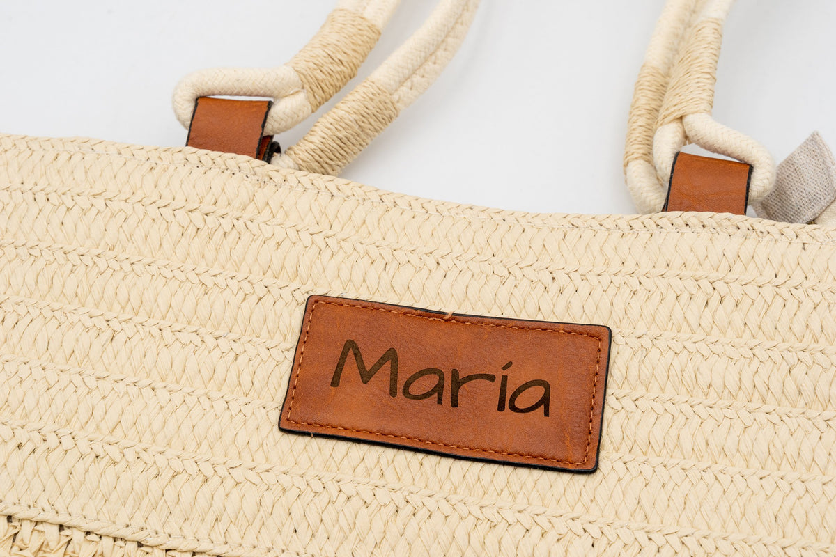 Patch of a natural raffia bag engraved with the name María