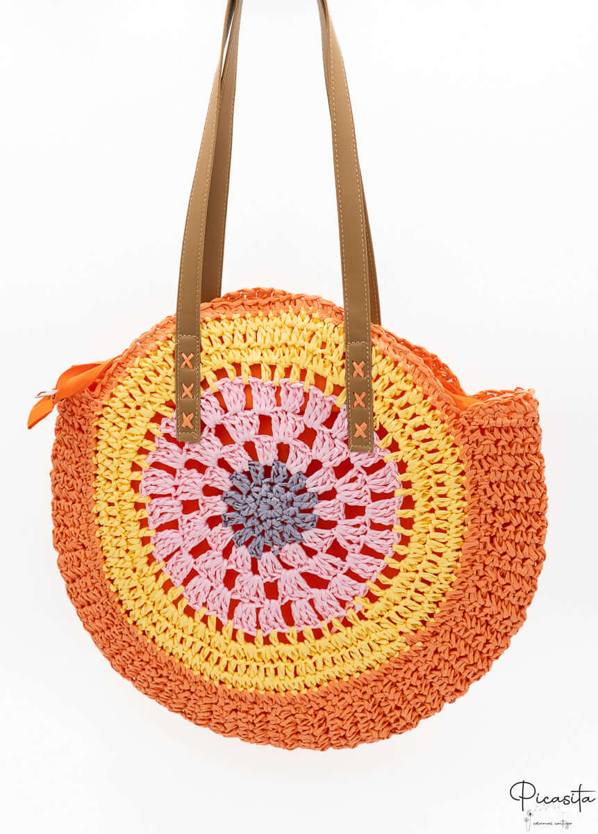 Bolso circular de verano con colores vibrantes naranja y amarillo trenzados.