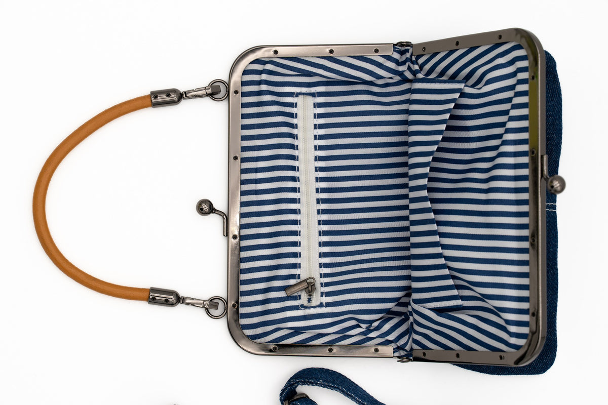 Inside of a bag with blue and white striped lining and an internal zipped pocket