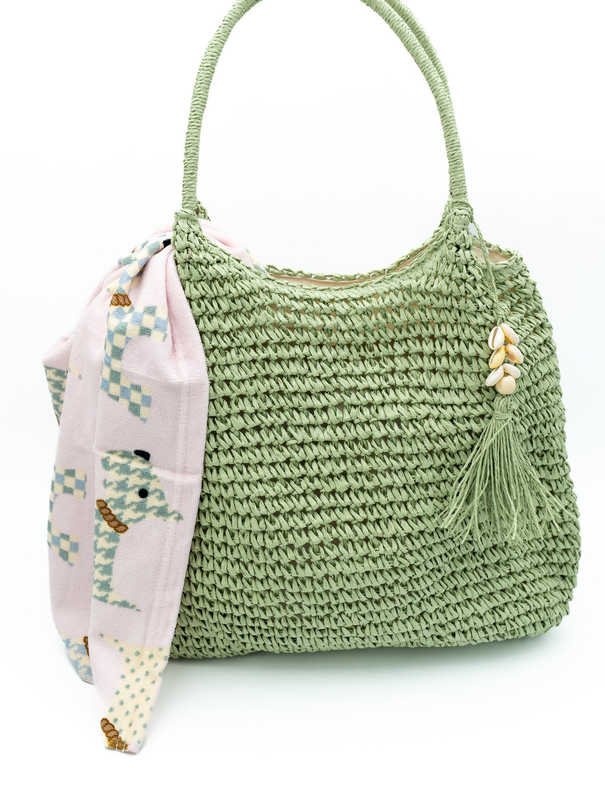 Woven olive-green hobo bag with a seashell tassel and pink geometric scarf.