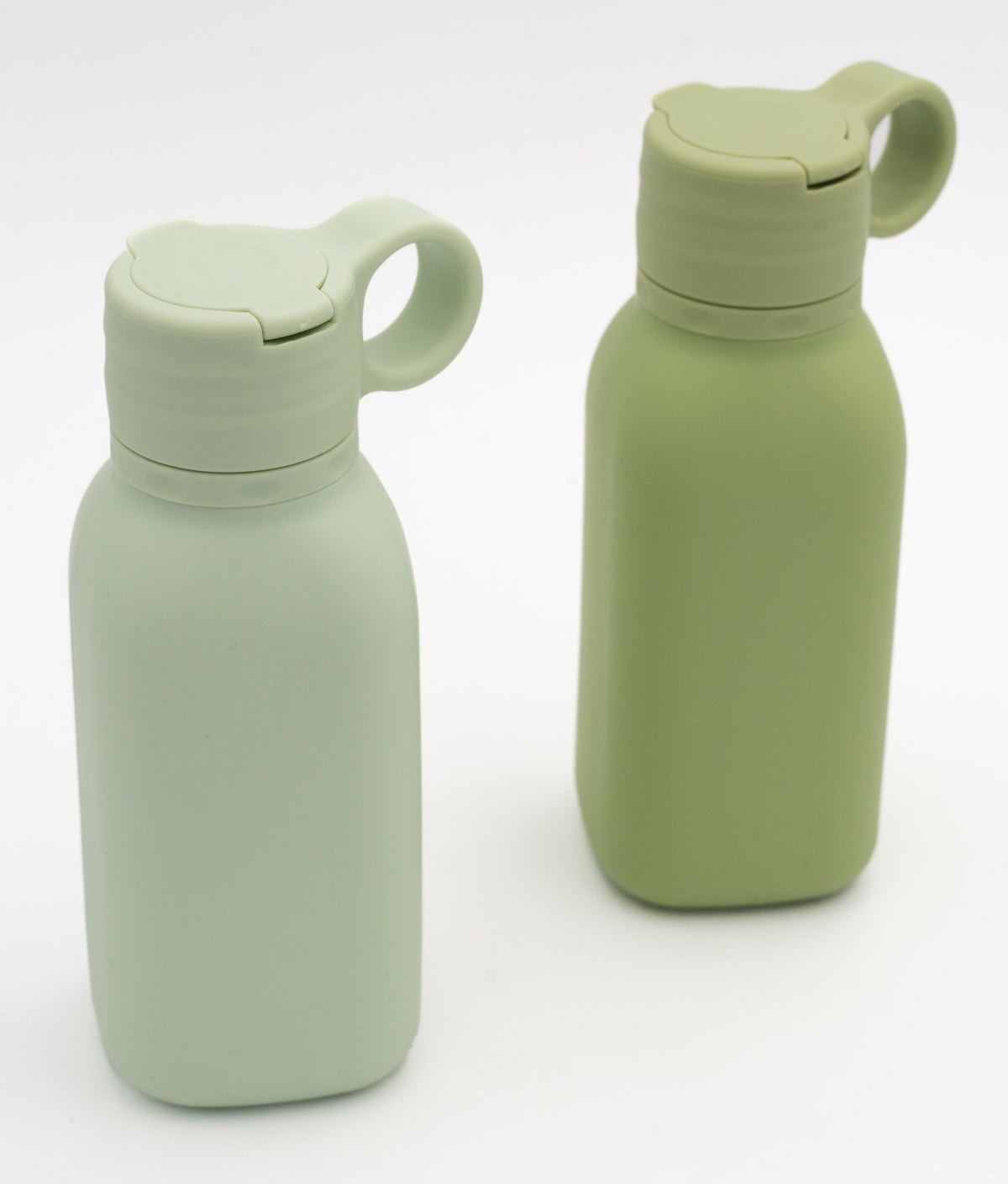 Two green bottles with closed lids