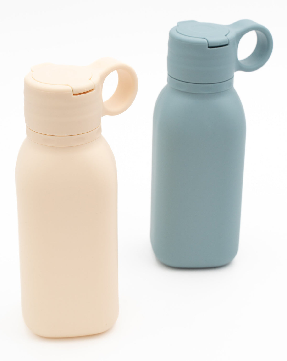 Two cream and blue-grey bottles with closed lids