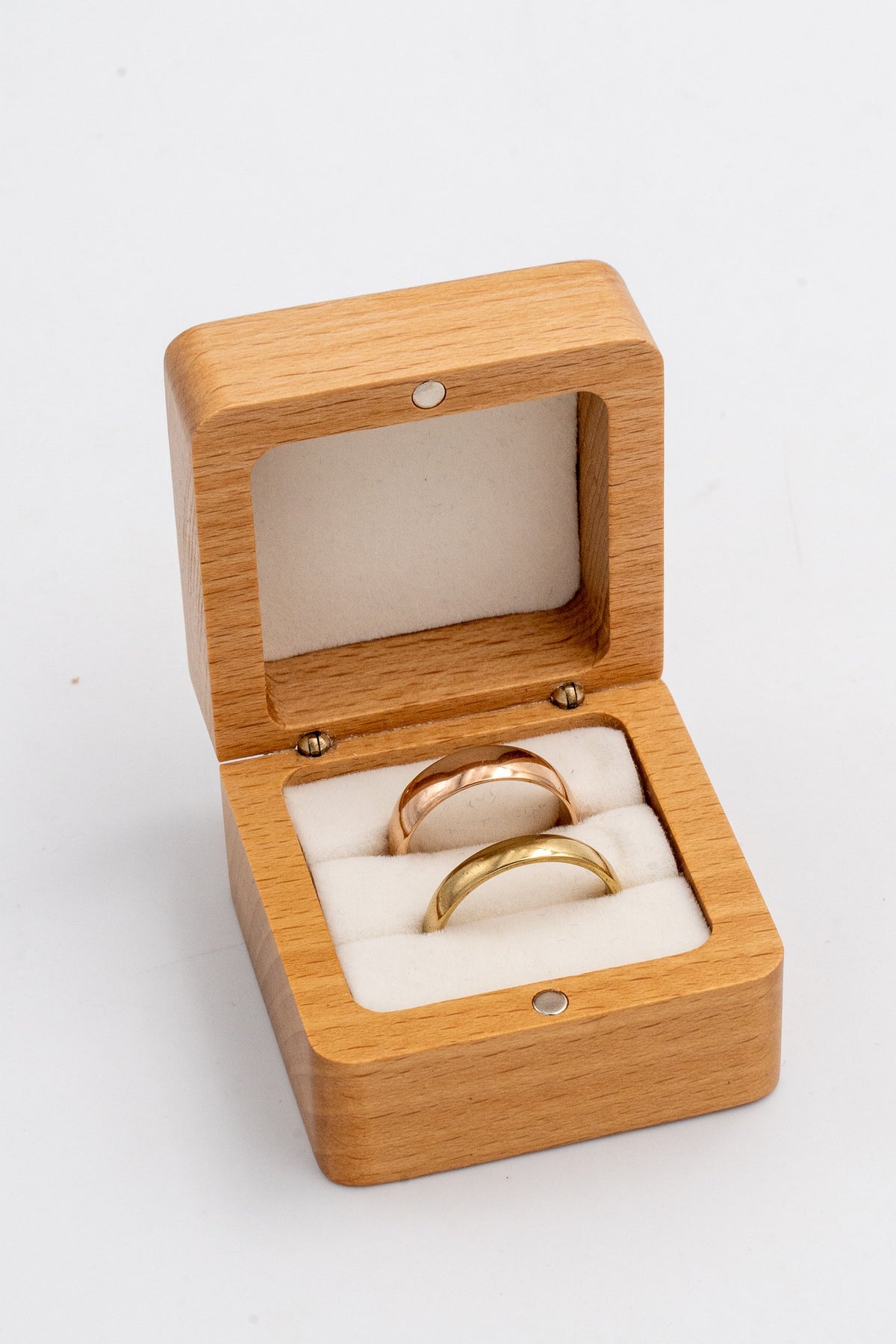 Square box with a white interior for two wedding rings