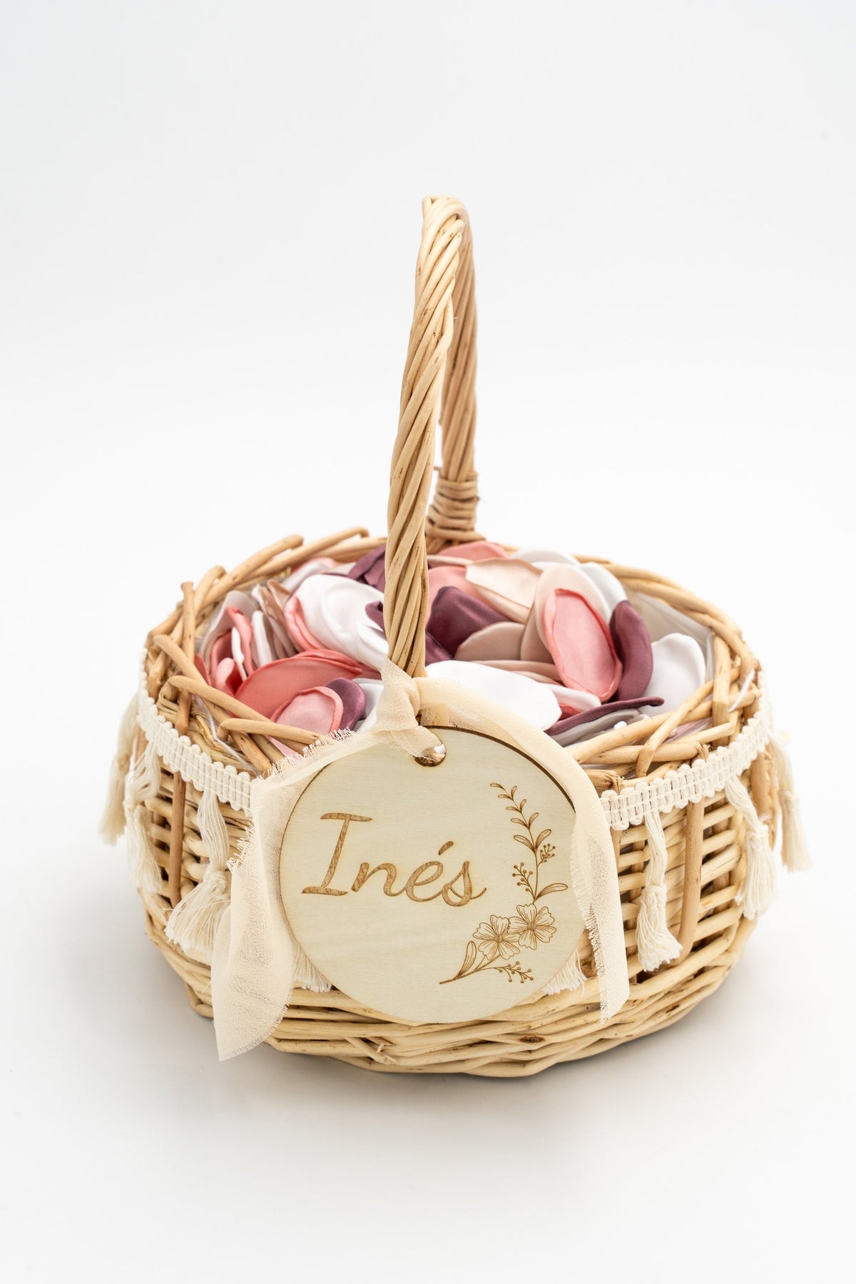 Rattan flower basket with white tassels and fabric petals in pink and white tones.
