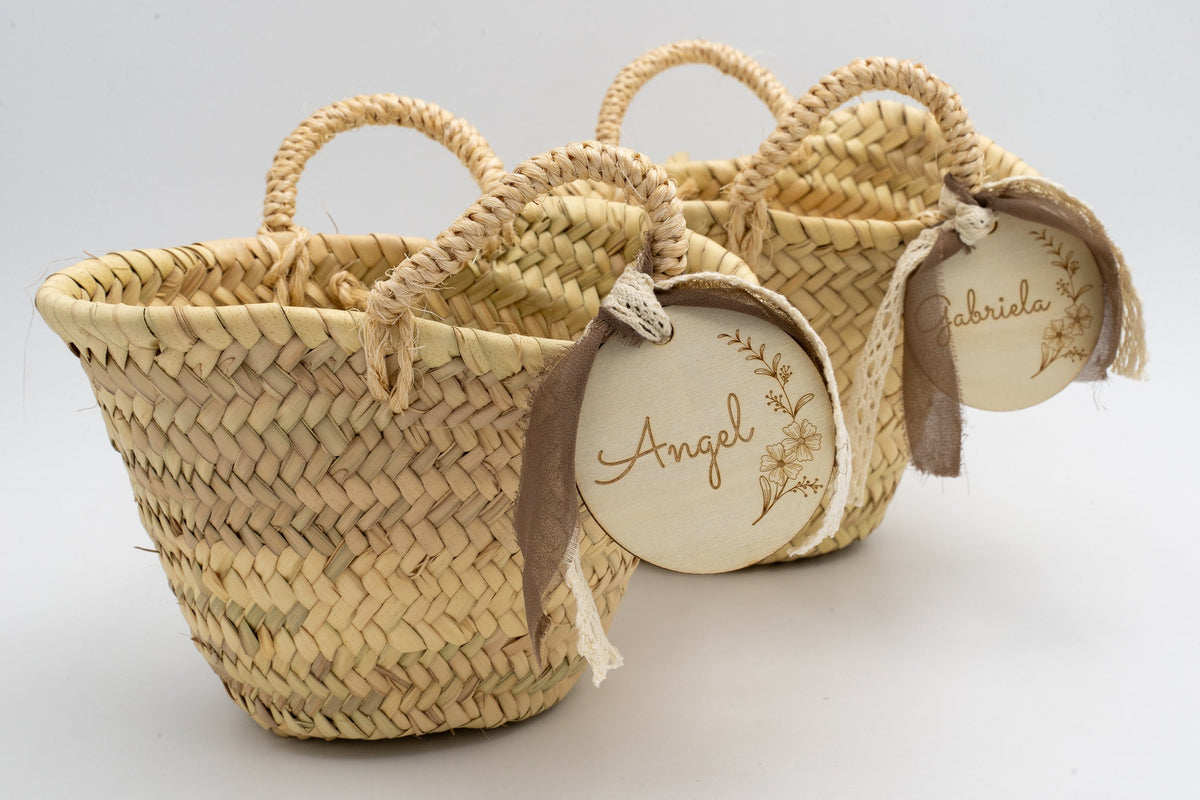Two palm baskets with double handles and decorative dark brown ribbons.