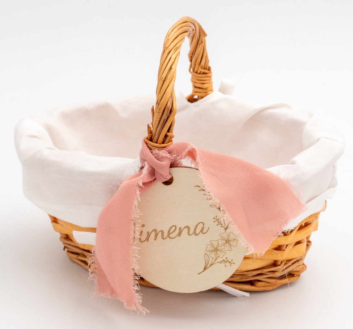 Basket with white fabric lining and a wooden circle engraved with the name Jimena