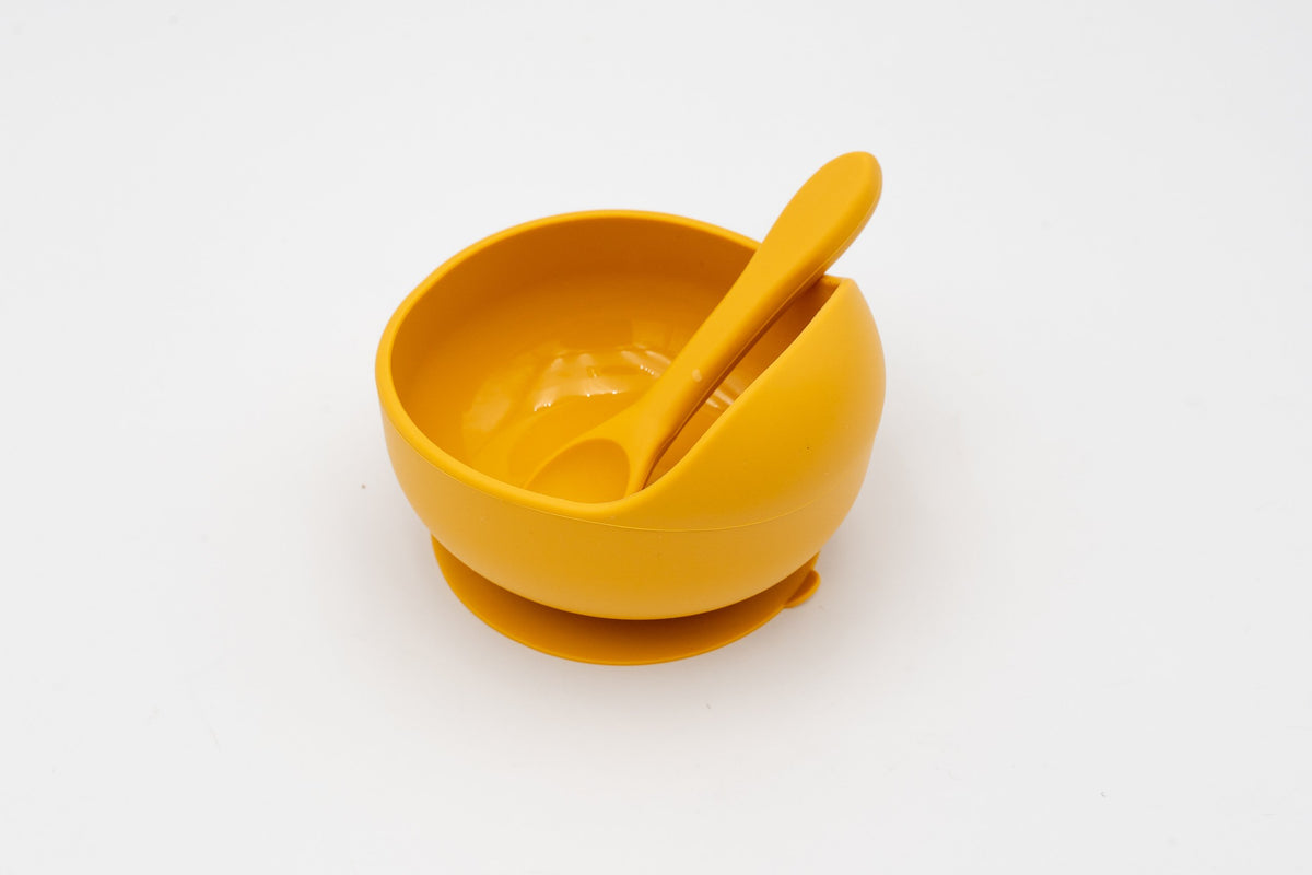 Mango-coloured bowl with suction base and silicone spoon