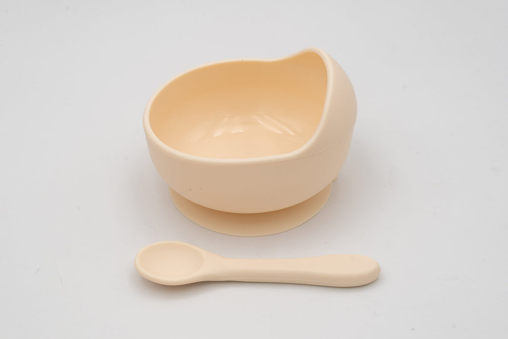 Cream-coloured bowl with suction base and separate spoon