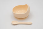 Cream-coloured bowl with suction base and separate spoon