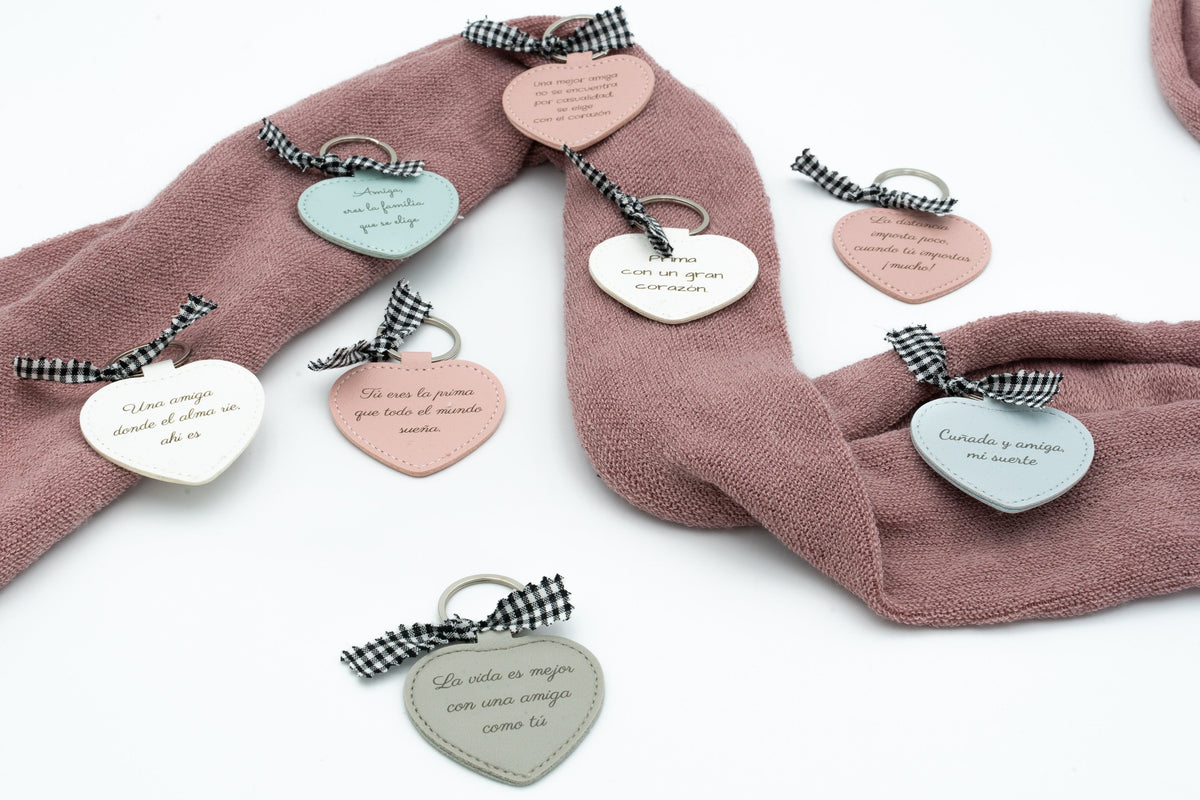 Heart keyrings in several colours with dedications on pink fabric.