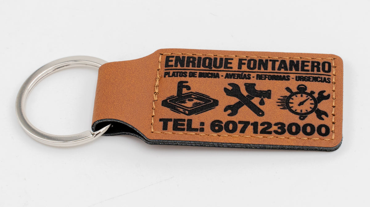 Brown rectangular keyring with a plumbing service logo and text.
