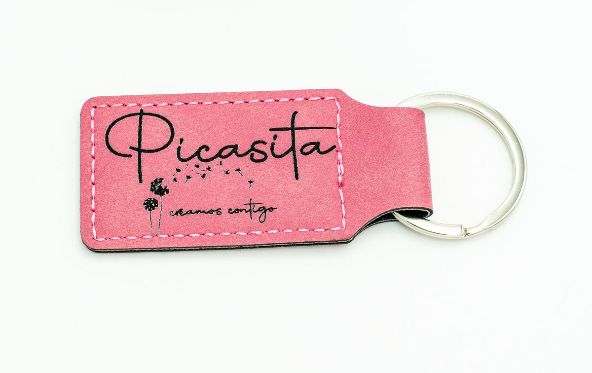 Pink rectangular keyring with a dark Picasita logo.