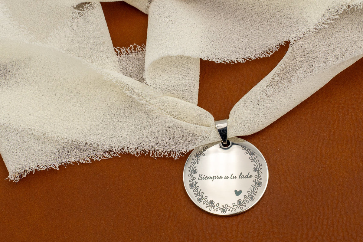 Mirror-finish steel charm with the phrase “Always by your side” and a floral border, tied with an ivory chiffon ribbon