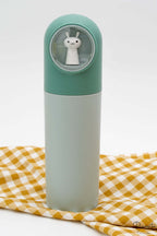 Estuche de polipropileno color verde con cúpula transparente y figura de conejo blanco.