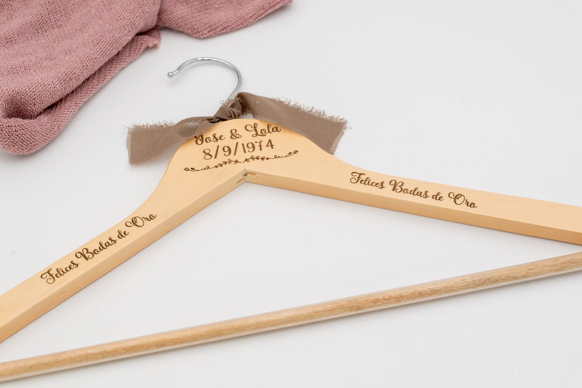 Wooden hanger with the names José and Lola and «Felices Bodas de Oro» engraved, with a brown bow