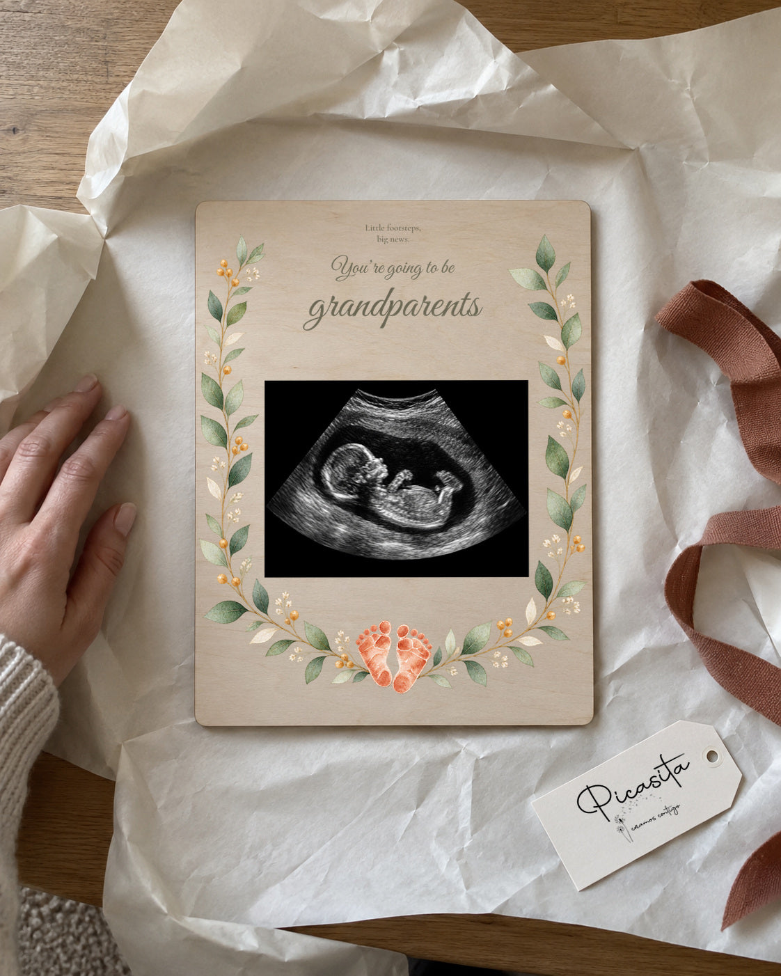 Simulated preview: Little footprints on Plywood, 15 × 20 cm, with an illustrative synthetic ultrasound. Gift scene.