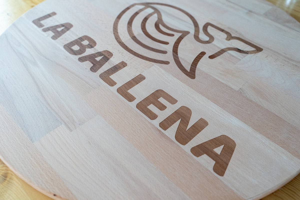 Vista oblicua del tablero redondo con el logotipo La Ballena grabado.