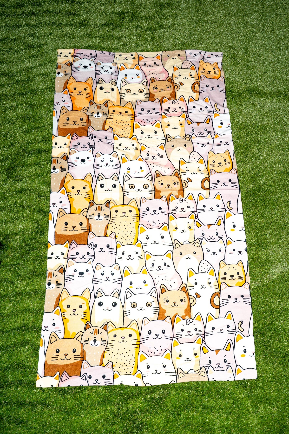Towel with a cat design in earth tones, beige and white on a light background