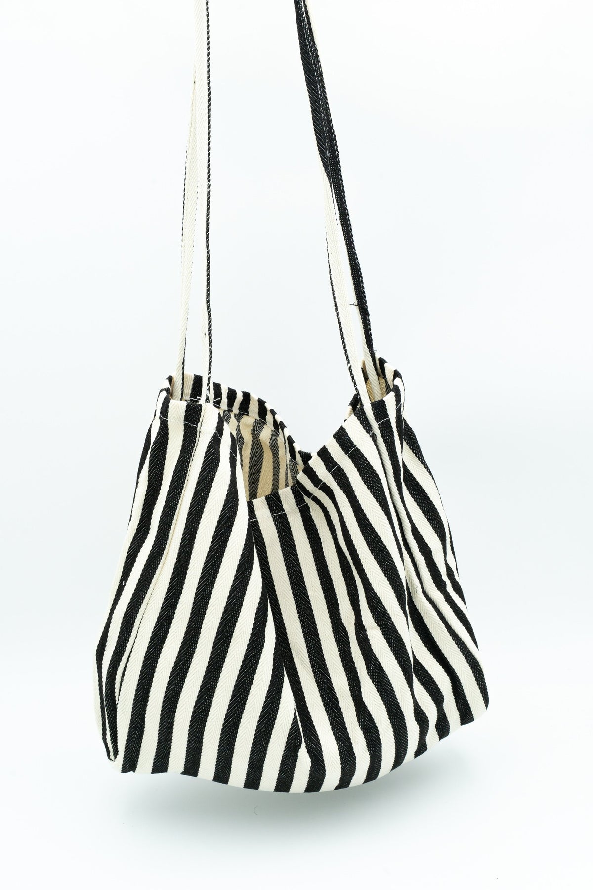Black and white striped fabric bag hanging by its handles