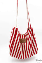 Tote bag de rayas rojas y blancas con parche de polipiel marrón central.