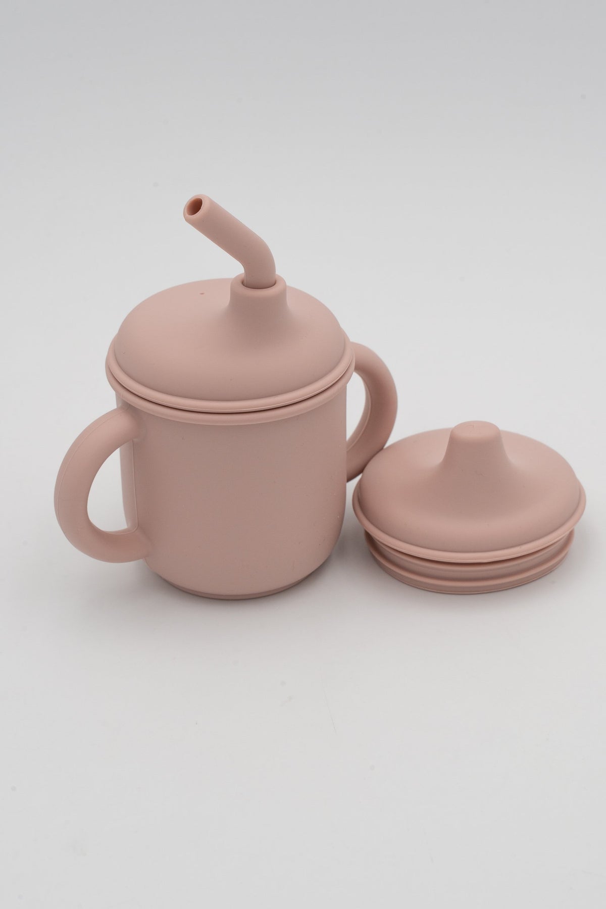 Light pink cup with a straw and second spout lid